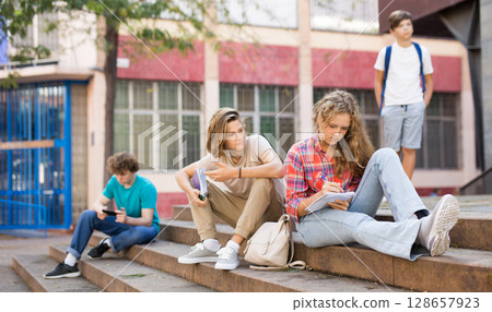 Teenagers on stairs beside of school Teenagers on stairs beside of school 128657923