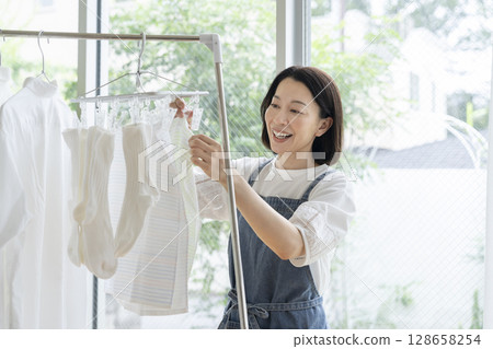 一位 50 多歲的女士正在晾衣服 128658254