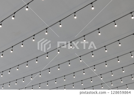 Soft glowing string lights hang across the ceiling creating a warm atmosphere 128659864