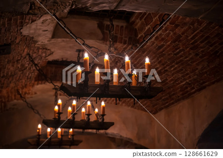 wrought iron chandelier with hanging fake candles on ceiling 128661629