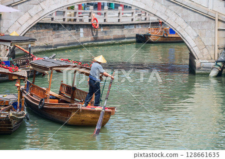 oarsman on tourist wooden boat at city god temple bridge, Zhujiajiao, Shanghai 128661635