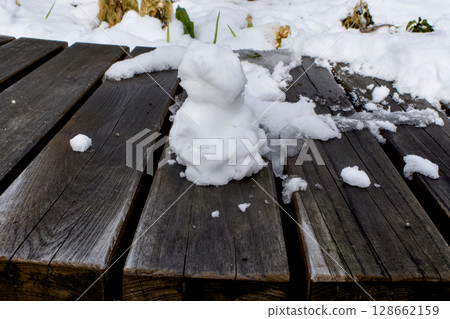 A small snowman on a bench A small snowman on a bench 128662159