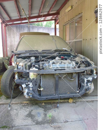 A dilapidated abandoned car 128662977