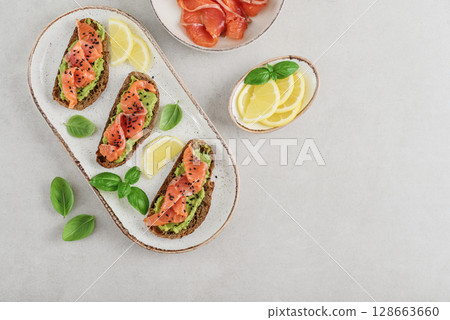 Open sandwiches with salted salmon and guacamole 128663660