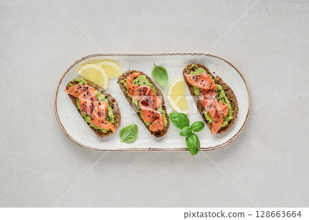Open sandwiches with salted salmon and guacamole 128663664
