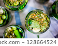 Homemade Pickled Cucumbers in Glass Jars with Spices and Herbs 128664524