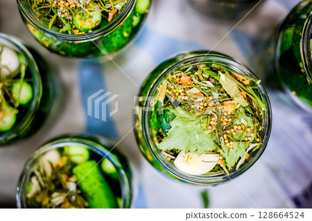 Homemade Pickled Cucumbers in Glass Jars with Spices and Herbs Homemade Pickled Cucumbers in Glass Jars with Spices and Herbs 128664524