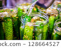 Homemade Pickled Cucumbers in Glass Jars with Spices and Herbs 128664527