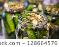 Homemade Pickled Cucumbers in Glass Jars with Spices and Herbs 128664576