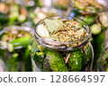 Homemade Pickled Cucumbers in Glass Jars with Spices and Herbs 128664597