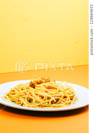 A classic plate of spaghetti with a rich, savory meat sauce, served on a white dish against an orange background. A classic plate of spaghetti with a rich, savory meat sauce, served on a white dish against an orange background. 128664655