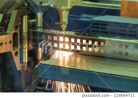 Close up scene the fiber laser cutting machine cut the square shape stainless steel tube with sparkling light. 128664711