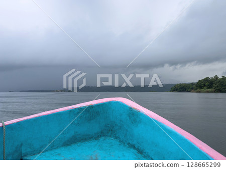 Boat nose on stormy sky background Boat nose on stormy sky background 128665299