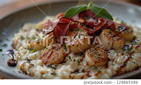 Close-up shot of classic truffle risotto with creamy Arborio rice, Parmesan shavings, truffle oil, fresh chives, and cracked black pepper. 128665399