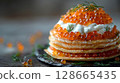 Elements of the Caviar Blini Tower levitate elegantly, showcasing layers of delicate blinis, rich cremer fraiche, and generous caviar, topped with a sprig of dill 128665435