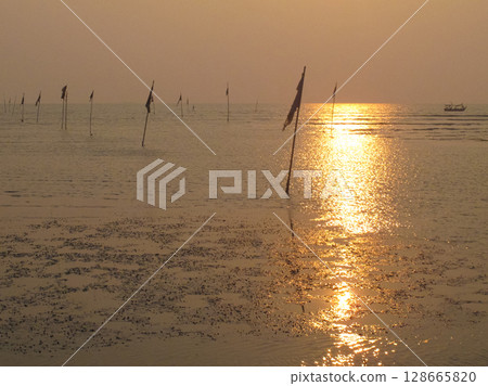 beautiful dramatic landscape of sunset on sea beach with silhouette of boat beautiful dramatic landscape of sunset on sea beach with silhouette of boat 128665820