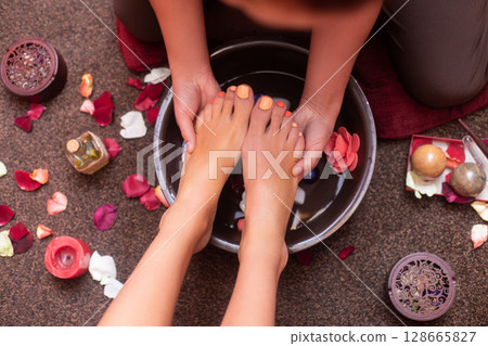 a masseuse in a cosmetology salon makes a Thai massage on the legs of a young girl a masseuse in a cosmetology salon makes a Thai massage on the legs of a young girl 128665827