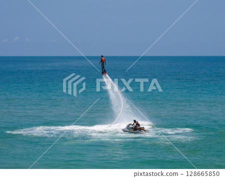 a guy flies on a flyboard at sea 128665850