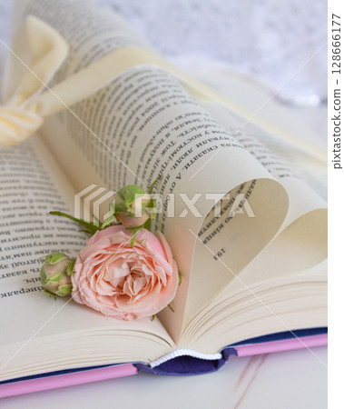 a beautiful arrangement of a bouquet of roses and a book 128666177