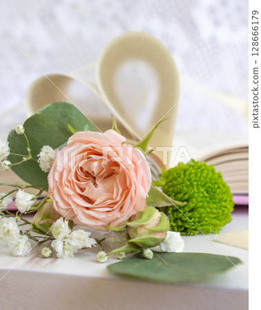 a beautiful arrangement of a bouquet of roses and a book a beautiful arrangement of a bouquet of roses and a book 128666179