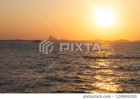 beautiful dramatic landscape of sunset on sea beach with silhouette of boat 128666300