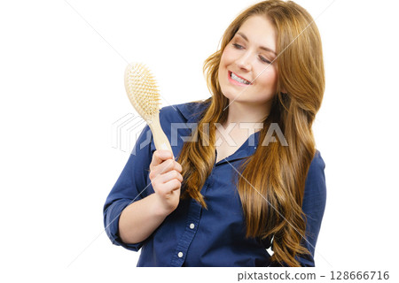 Woman brushing long healthy brown hair 128666716