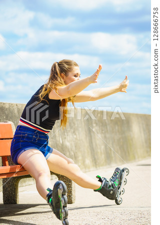 Joyful girl wearing roller skates Joyful girl wearing roller skates 128666758