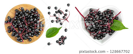 Ripe black elderberry or elder with green leaves in wooden bowl isolated on a white background. Sambucus Ripe black elderberry or elder with green leaves in wooden bowl isolated on a white background. Sambucus 128667702