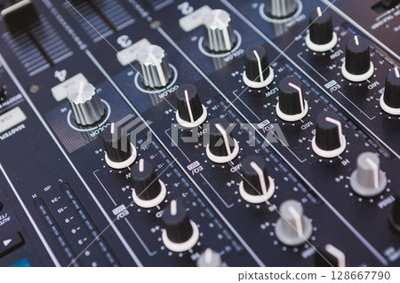 Close-up of a professional audio mixer's faders and knobs Close-up of a professional audio mixer's faders and knobs 128667790