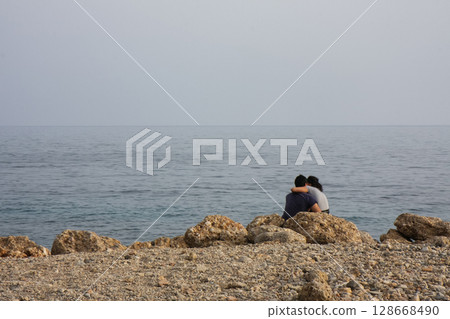 a couple in love rests on a sea beach a couple in love rests on a sea beach 128668490