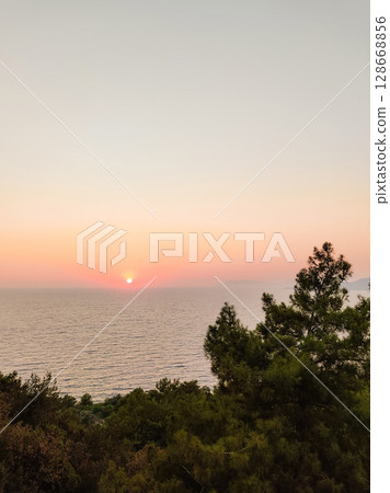 beautiful sunset on the sea with a red sun on the horizon 128668856