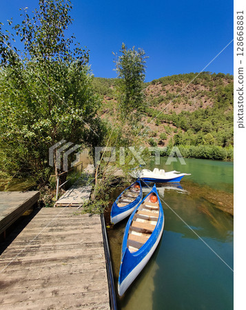 canoes are moored on the lake near the pier 128668881