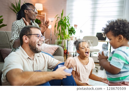 Family enjoying joyful moments in a cozy living room 128670509