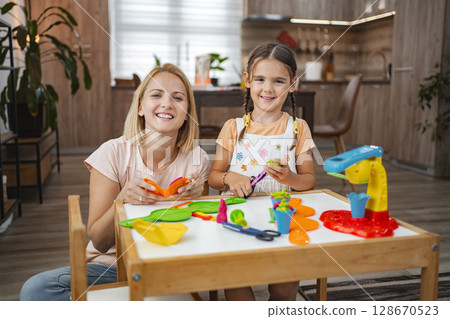 Mother and daughter enjoying creative playtime modeling plasticine 128670523
