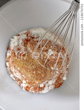 spices with salt and baking powder are mixed in a white bowl spices with salt and baking powder are mixed in a white bowl 128670701