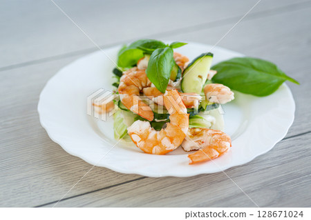 Juicy salad with seafood on a wooden table 128671024