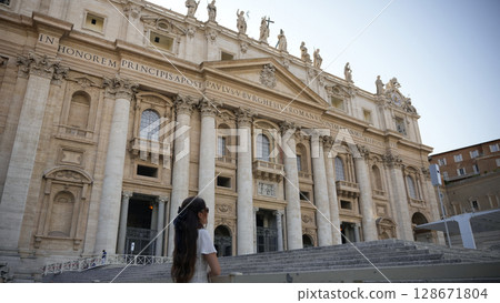 Woman in white dress gazing at Basilica facade Vatican, Italy July 20 2025  Woman in white dress gazing at Basilica facade Vatican, Italy July 20 2025  128671804