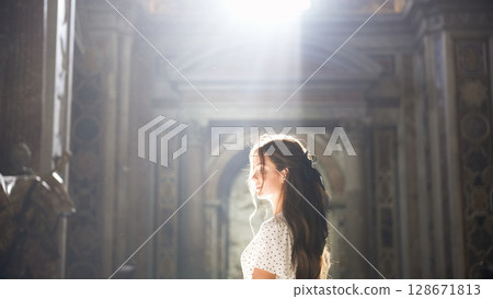 Woman admiring Roman church interior with soft natural light  128671813