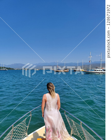 beautiful girl on the deck of a boat while traveling on the sea with a view of the mountains beautiful girl on the deck of a boat while traveling on the sea with a view of the mountains 128671972