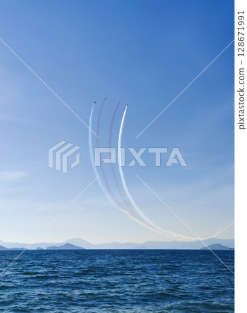 a beautiful air show of fighter jets in the sky over the sea 128671991