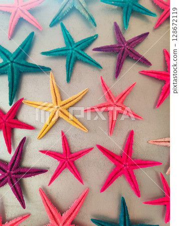 a composition of colored starfish on a gray background 128672119
