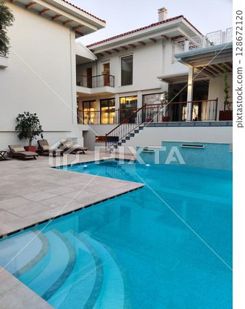a beautiful large swimming pool near the house 128672120