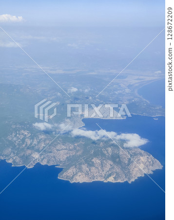 beautiful thick clouds in the sky from the height of the flight of the plane with a view of the continent and countries 128672209