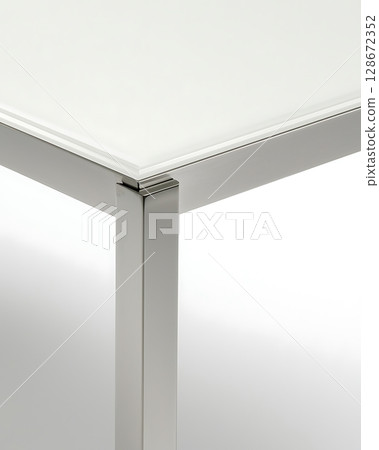 A table with a glass top and metal legs 128672352