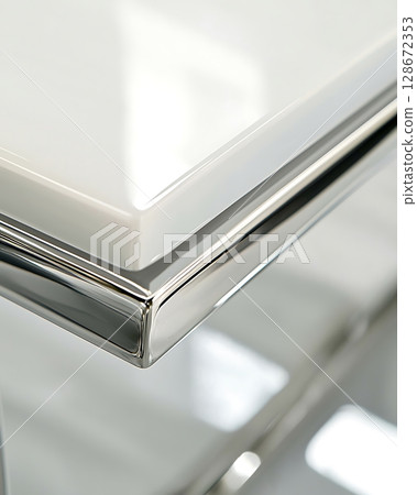 A table with a shiny silver edge and a white top 128672353