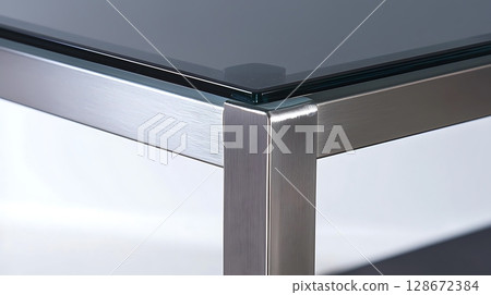 A table with a glass top and metal legs A table with a glass top and metal legs 128672384