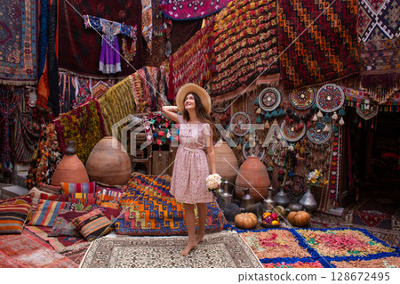 a beautiful girl in dress in a traditional turkish interior with many carpets on the wall a beautiful girl in dress in a traditional turkish interior with many carpets on the wall 128672495