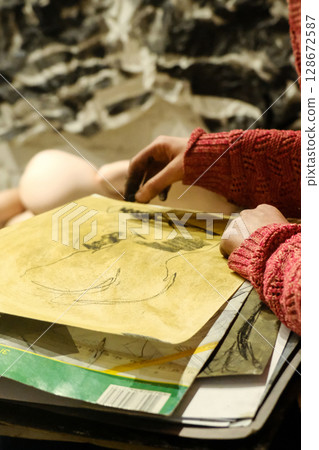 Artist touches charcoal sketch using blending technique Artist touches charcoal sketch using blending technique 128672587