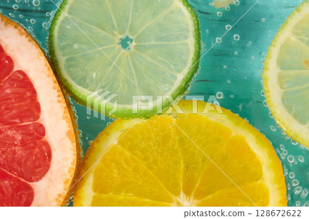 Fresh citrus fruits in sparkling water create a refreshing summer drink experience with vibrant colors and textures Fresh citrus fruits in sparkling water create a refreshing summer drink experience with vibrant colors and textures 128672622
