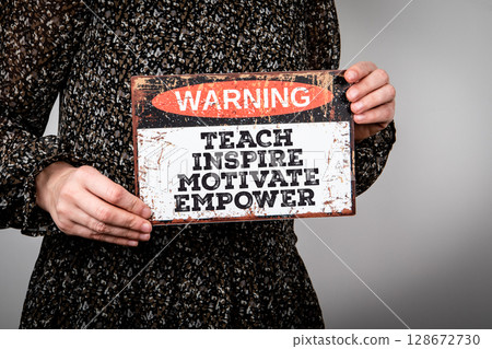 Woman Holding Inspirational Sign with Motivational Message to Teach, Inspire, Motivate, Empower 128672730
